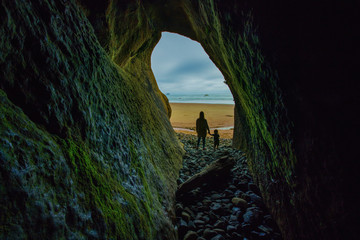 Mom and son looking out of cave out to the ocean