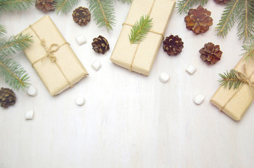 Christmas background tree branches cones and gifts on wooden white background 
