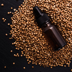 coriander seeds on a dark stone background, essential oil