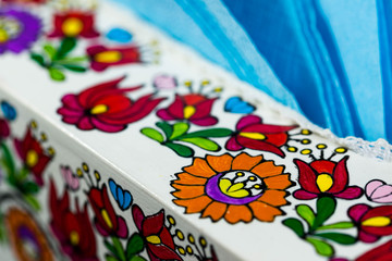 Fototapeta na wymiar Hand painted colorful hungarian pattern on napkin holder at local restaurant.
