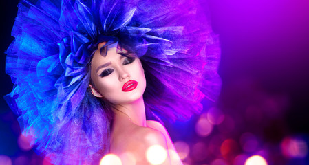 Naklejka premium Fashion model woman in colorful bright lights posing. Portrait of beautiful sexy girl with trendy makeup and colorful hairdo. Art design