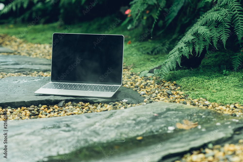 Poster laptop computer mockup has empty screen outside on stone