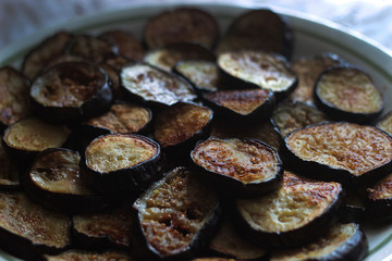 slices of fried eggplant close-up in a large round plate