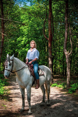Pretty girl lady at countryside with white horse. A beautiful rider and horse. Artistic Photography at horse farm. Attractive girl riding on horse rural location 