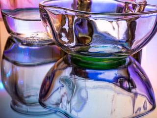 Glass of water with drop and colored background