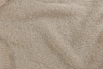 Closeup industrial knitted textile in nude and gold colors as background