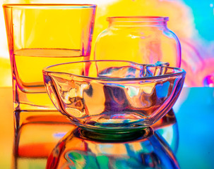 Glass of water with drop and colored background
