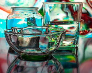 Glass of water with drop and colored background