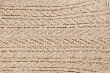 Closeup knitted textile pattern in beige color as background