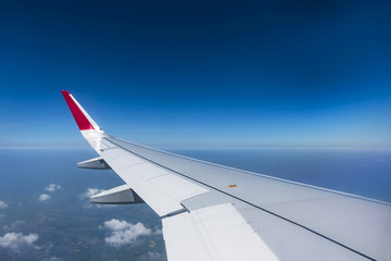 Obraz premium Airplan wing above the blue sky