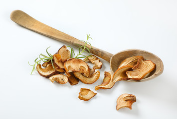 handful of dried mushrooms and wooden spoon