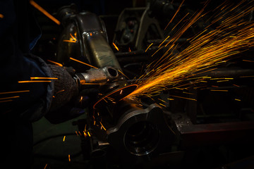 Industry worker cutting metal with grinder
