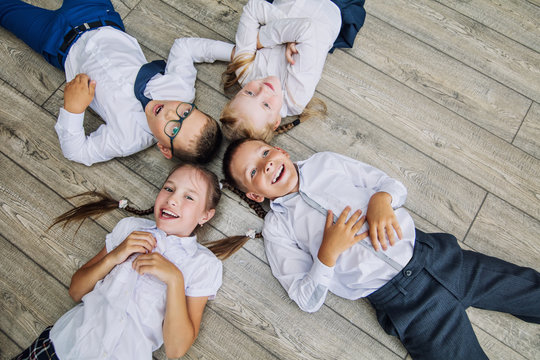 Group of children in school uniform cheerful and beautiful smile lying on the floor