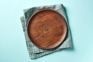 Wooden plate on blue background, from above