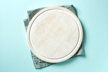 Wooden cutting board on blue background, from above