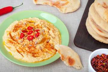 Plate of delicious homemade hummus with freshly baked pita bread close-up