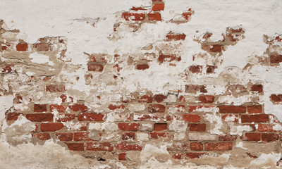 old weathered brick wall with white plaster