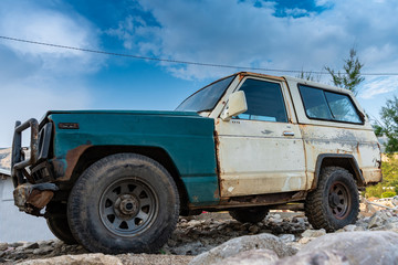 The old rugged off-road vehicle stuck in a rocky terrain