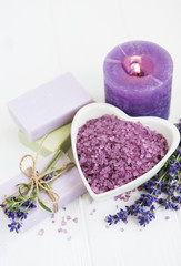 Fototapeta na wymiar Heart-shaped bowl with sea salt, soap and fresh lavender flowers