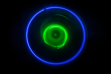 Music concept. Freezelight glowing vinyl on dark background or Turntable playing vinyl with glowing abstract lines concept on dark background.