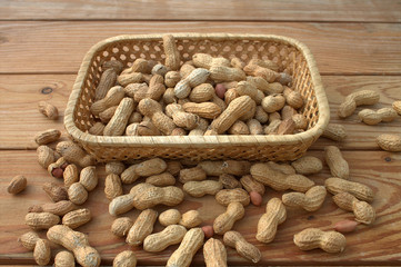 Fototapeta na wymiar Peanuts in a wicker basket against the old tree background