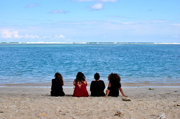 Four girls watching the coral reef line in Saline les Bains, Reunion Island. Diversity