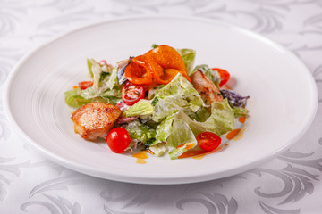Bowl of salad with duck, orange and vegetables. Asian food. Salad on a white dish on table. restaurant menu