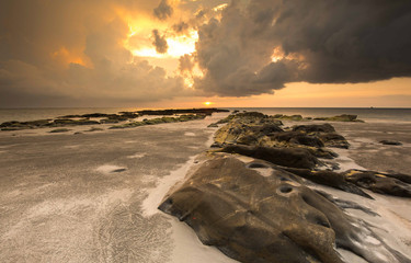 Beautiful sunset with natural coastal rocks at Unknown Beach in Sabah, Malaysia.