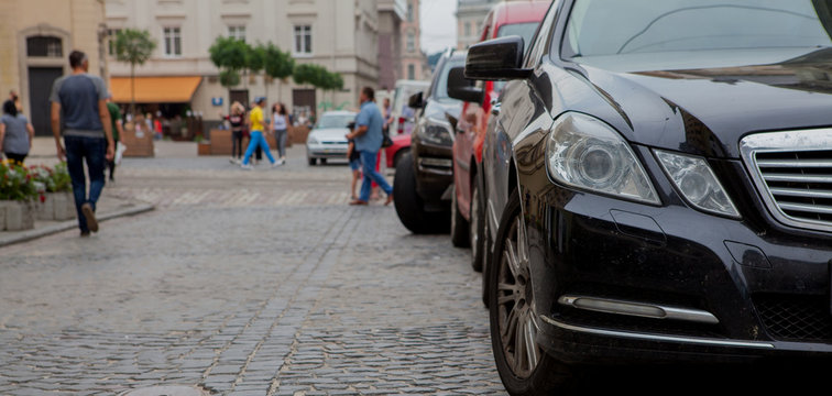 Fototapeta Close-up headlight of black modern car with other cars on background