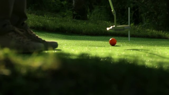 Perfect golf putt. Three orange balls