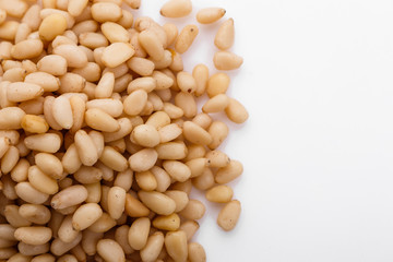 peeled pine nuts on a white acrylic background