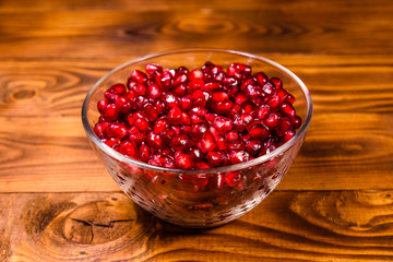 Seeds of the garnet fruit in glass bowl on wooden table