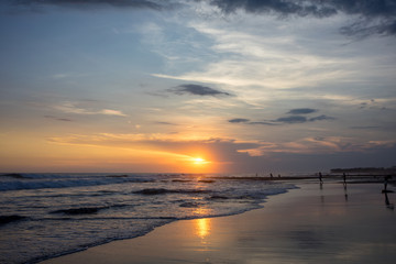 Obraz premium people on tropical beach at sunset