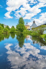 Fototapeta na wymiar The monastery tower and the wall in Vologda are reflected in the lake