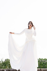 Girl standing outside in long white dress