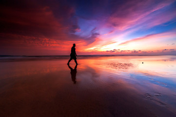 Sunrise with beautiful reflection.  silhouette  of unknown people appear on the image. 