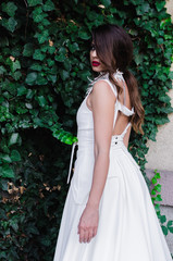 Young woman posing in long white dress