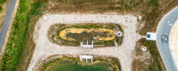 Vertically aerially taken in front basin or stilling basin of a rainwater retention basin in a new development area