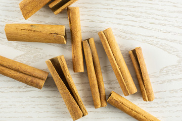 Lot of whole dry brown cinnamon stick flatlay on grey wood