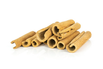 Lot of whole dry brown cinnamon stick heap isolated on white background
