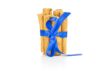 Lot of whole dry brown cinnamon stick tied by electric blue silk ribbon tied by ribbon isolated on white background
