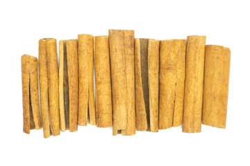 Lot of whole dry brown cinnamon stick in line flatlay isolated on white background