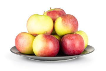 Lot of whole fresh red apple james grieve variety on grey ceramic plate isolated on white background
