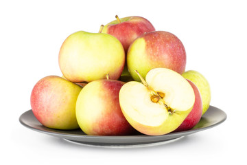 Lot of whole one half of fresh red apple james grieve variety on grey ceramic plate isolated on white background