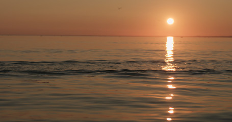 small waves on a beach at sunset