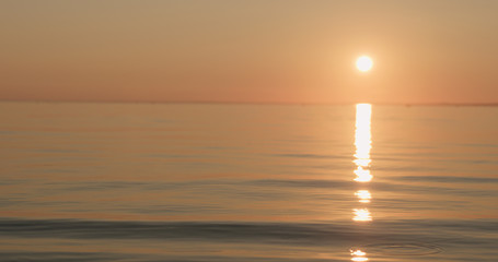 small waves on a beach at sunset