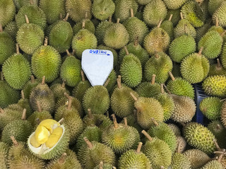 Yellow and green ripe durians being sold at a local market in Malaysia.