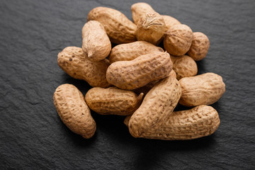 fresh peanuts on a dark stone background