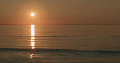 small waves on a beach at sunset
