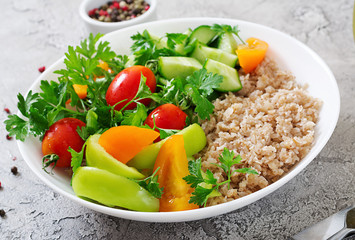 Diet menu. Healthy vegetarian salad of fresh vegetables - tomatoes, cucumber, sweet peppers and porridge on bowl. Vegan food.